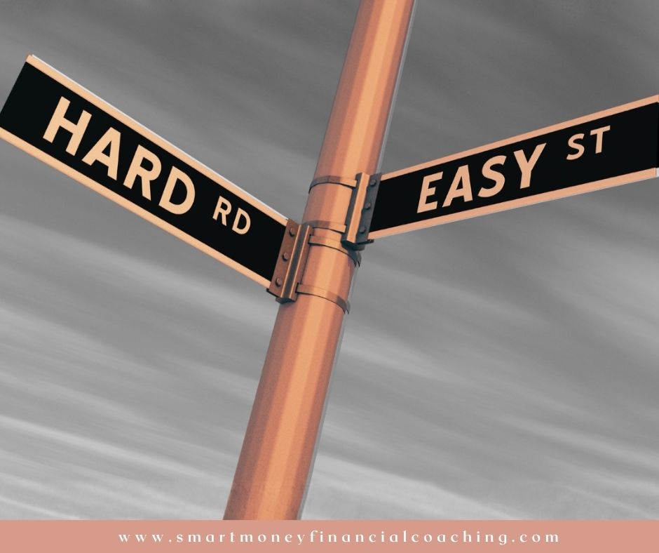 Street sign showing “Hard Rd” and “Easy St” representing why money feels hard before it feels easier